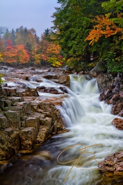 Vertical image of Rocky Gorge on the Swift River in the White Mountains of New Hampshire. Vibrant fall foliage can be seen on the far bank above the gorge.